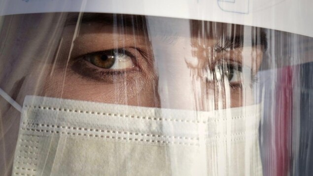 Une femme qui porte un masque de protection