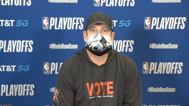 Nick Nurse, l'entraîneur-chef des Raptors, en conférence de presse portant un masque de l'artiste torontoise Nadia Lloyd.