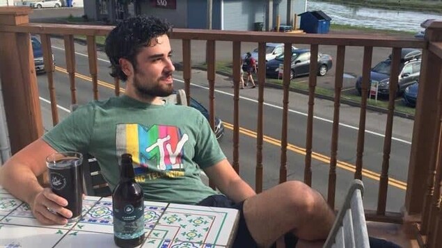 Matteo Dabbene assis sur une terrasse sirote une bière.