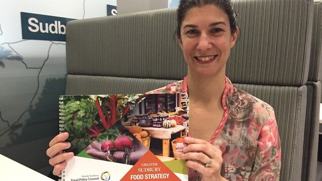 Jennifer Babin-Fenske nous montre le cahier de la Stratégie alimentaire du Grand Sudbury