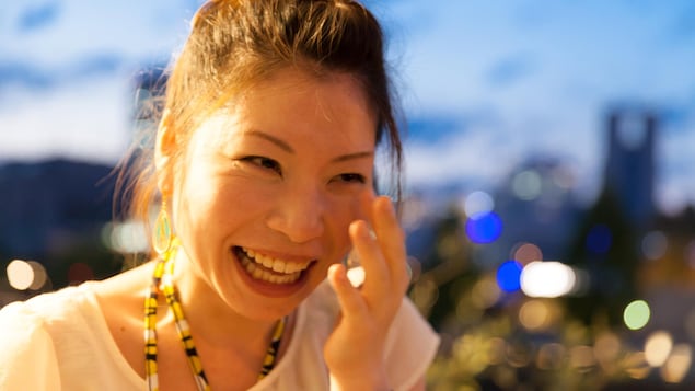 Une femme d'origine asiatique pleure tellement elle rit de bon cœur.