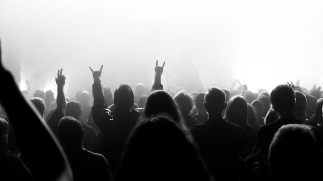 Silhouettes de personnes assistant à un spectacle de musique.