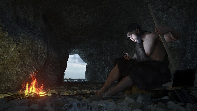 Un homme dans un caverne tient une cellulaire dans ces mains.