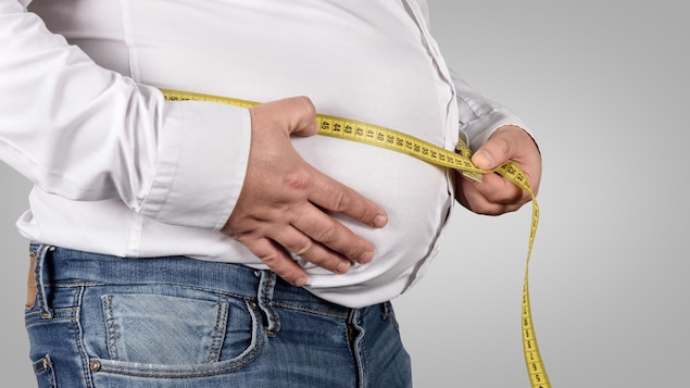 Un homme obèse mesure son tour de taille.