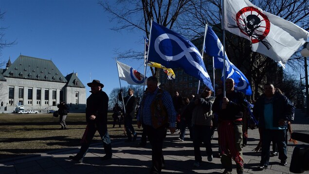 Des autchtones manifestent dans la rue, drapeaux à la main