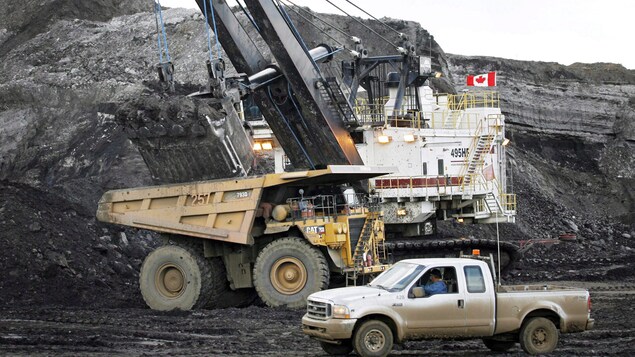Une pelle minière remplit un camion de transport sur une mine de sables bitumineux près de Fort McMurray, en Alberta.