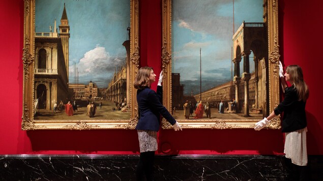 Deux employées du Palais de Buckingham, à Londres, déplacent une peinture de Canaletto.