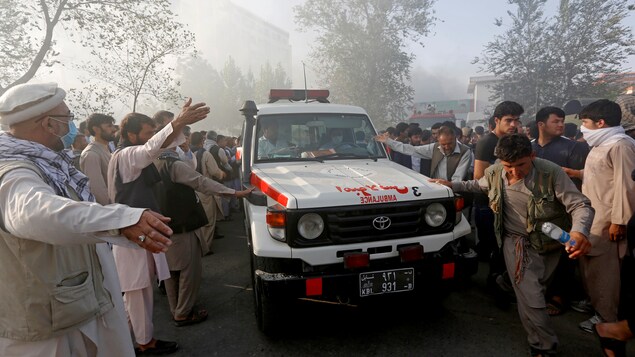Le 25 août 2017, des Afghans laissent passer une ambulance après un attentat-suicide. 
