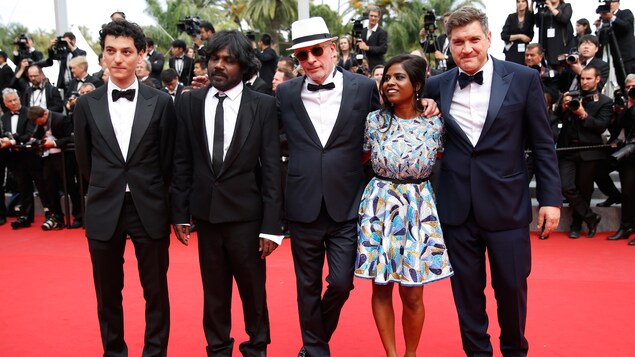 Le réalisateur Jacques Audiard est entouré des acteurs de son film La glace et le ciel sur le tapis rouge du festival de Cannes de 2015.