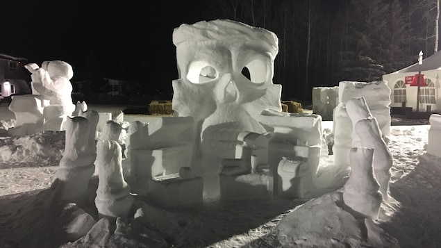 Des sculptures de neige dans un paysage hivernal nocturne.
