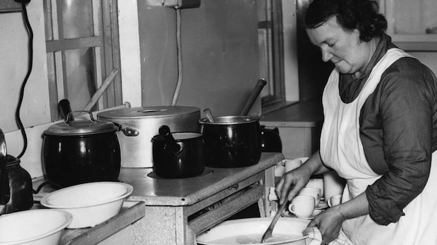 Une femme faisant la cuisine sur une photo en noir et blanc.