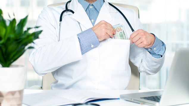Un médecin se met de l'argent dans les poches.