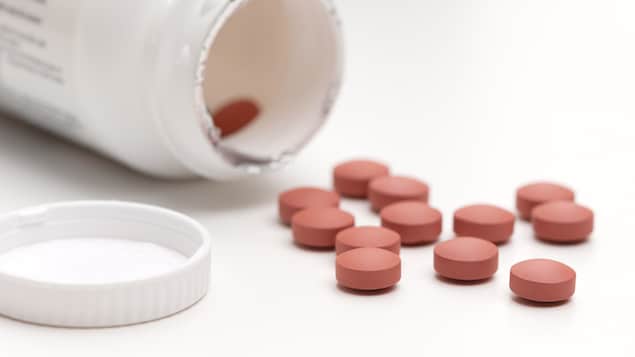 Une bouteille renversée de pilules d'ibuprofène Une bouteille renversée de pilules d'ibuprofène