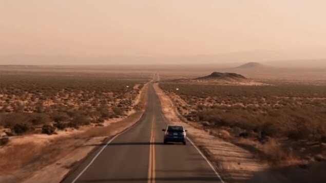Un voiture roule sur une autoroute dans le désert américain.