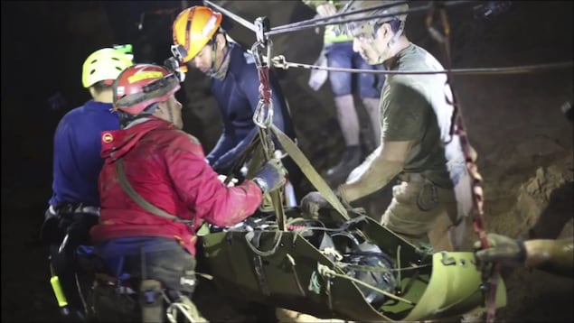 Des sauveteurs en train de secourir les 12 jeunes et leur entraîneur Des sauveteurs en train de secourir les 12 jeunes et leur entraîneur