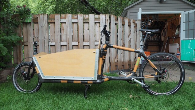 Un vélo allongé dont la partie antérieure au guidon est occupée par un réceptacle.