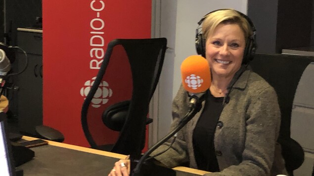 Monique Dubreuil est assis devant un micro du studio 1 de la station de Radio-Canada à Sudbury sur la rue Elm.