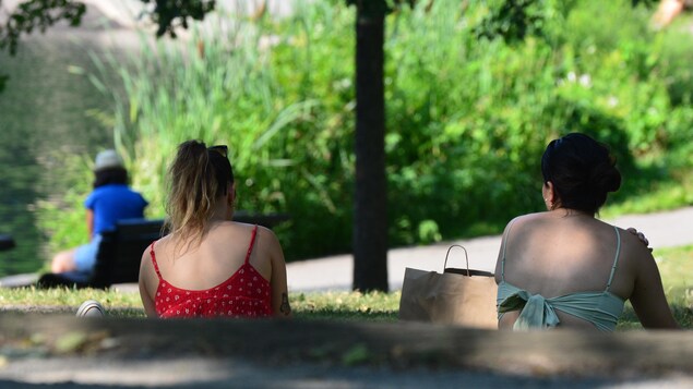Deux jeunes femmes assises dans un parc de Montréal.