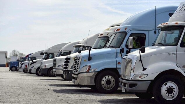 Plusieurs camions de livraison dans un stationnement.