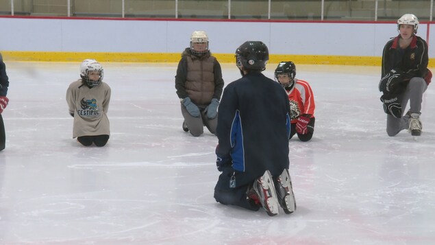 Des enfants et des entraîneurs sur la glace Des enfants et des entraîneurs sur la glace