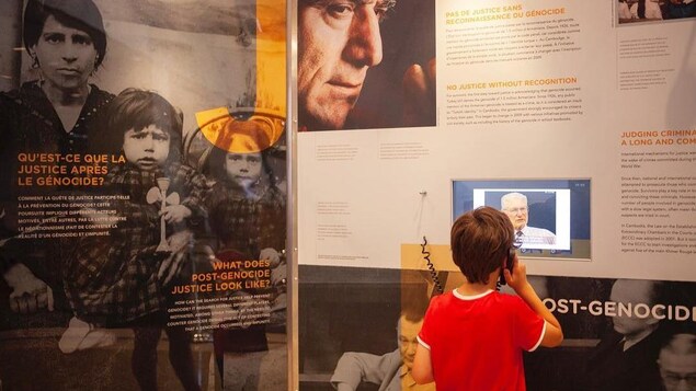 Un jeune garçon visite l'exposition « Ensemble contre le génocide ».