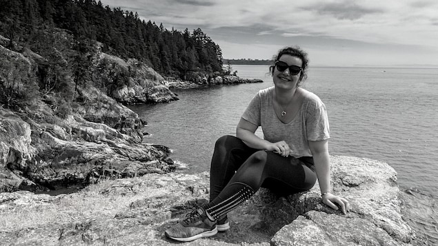 Gwendoline Decat-Beltrami assise sur un rocher sur le bord de l'eau.