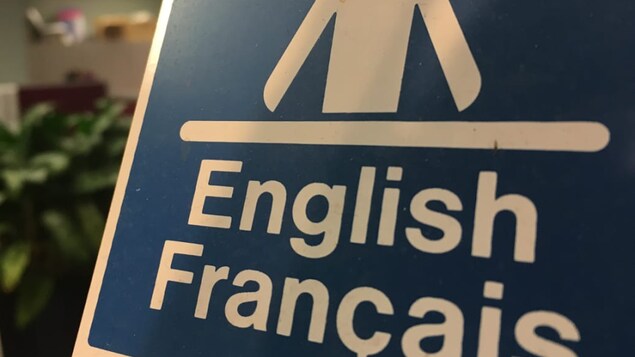 Affiche annonçant des services bilingues.