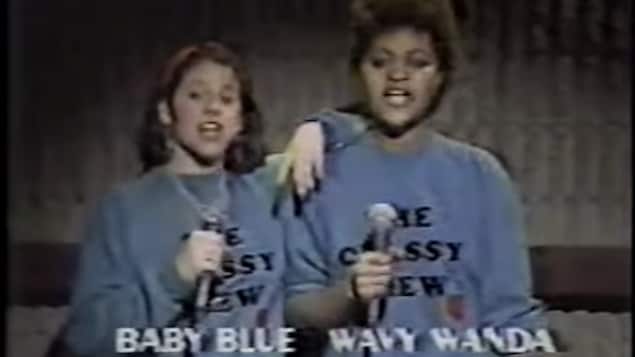 Capture d'écran un peu brouillée de Baby Blue et Wavy Wanda avec un chandail coton ouaté portant l'inscription «Classy Crew». Elles tiennent un micro et son en train de rapper. 