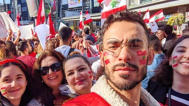 أشخاص يحملون أعلاما لبنانية.
