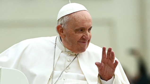 Gros plan sur le pape François qui salue des gens à son arrivée pour l'audience générale hebdomadaire sur la place Saint-Pierre, au Vatican, le 4 mai 2022.