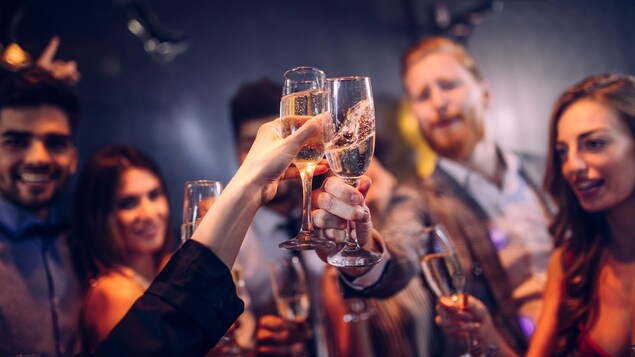 Plusieurs personnes trinquent avec des coupes de champagne.