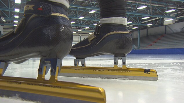 Un gros plan de patins de vitesse sur une glace intérieure. 