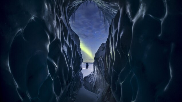 Un homme se tient entre des murs de glace.