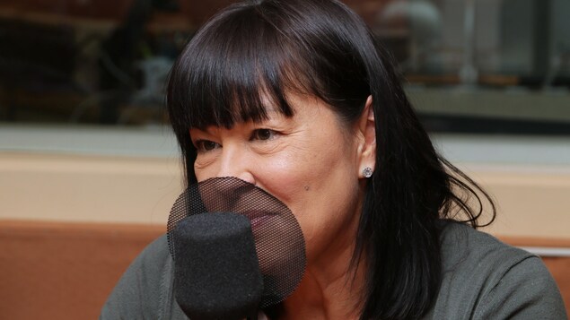 Photo de Chantal Petitclerc devant un micro de radio.