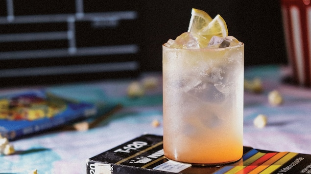 Une boisson est servie dans un verre avec de la glace et des rondelles de citron. 