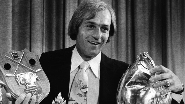 Guy Lafleur pose avec trois trophées.