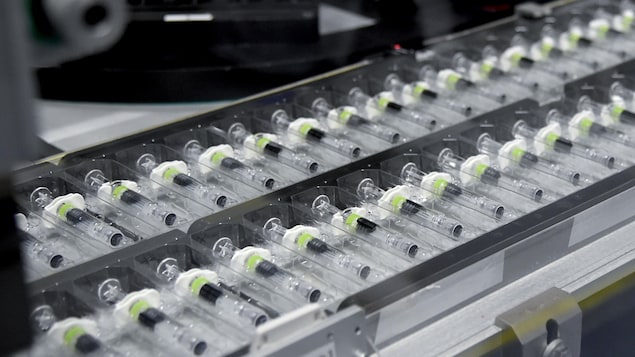 Des seringues vides sur une ligne de production dans une usine.