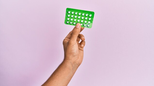 Gros plan sur une main qui tient une plaquette de pilule contraceptive.