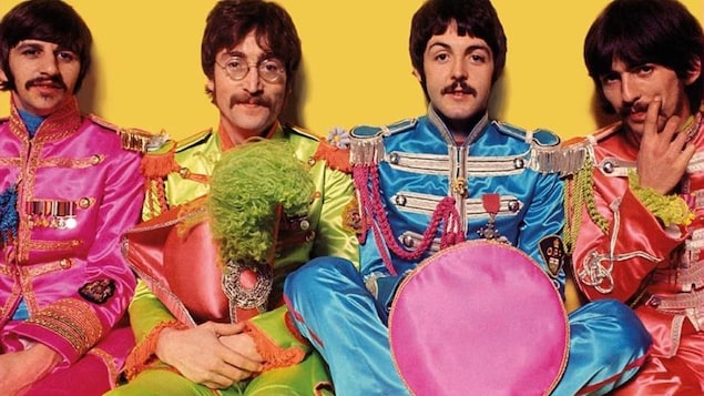 Les 4 membres du groupe The Beatle dans des costumes colorés.