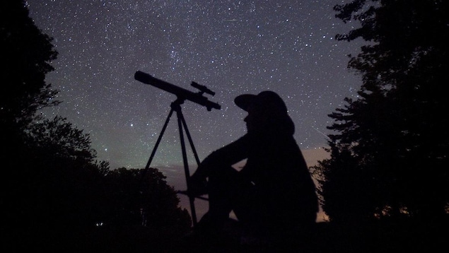 Un astronome amateur avec son télescope.  