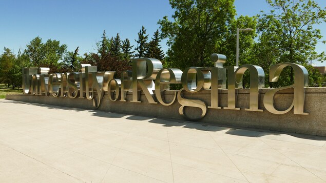 Des lettres en métal formes les mots University of Regina sur un muret. 