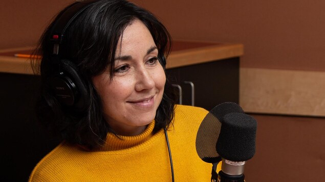 L'autrice vêtue d'un pull jaune sourit à l'animatrice.
