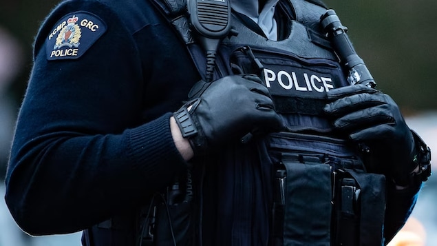 Un agent porte l'uniforme de la Gendarmerie royale du Canada.