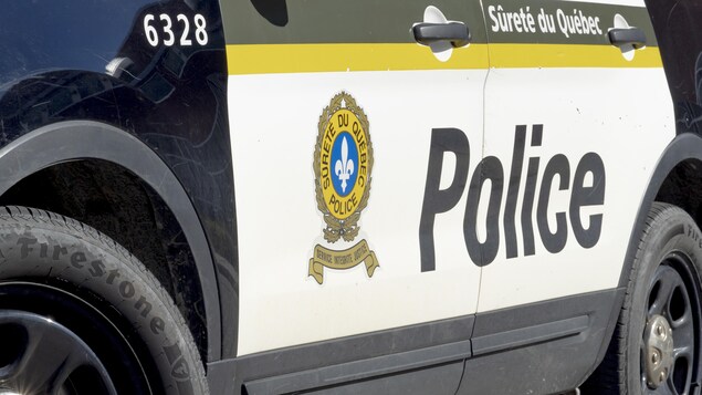 Une voiture de police stationnée près d'une scène d'intervention.