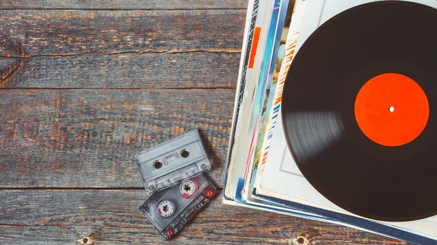 Des disques vinyles et des cassettes sur une table en bois