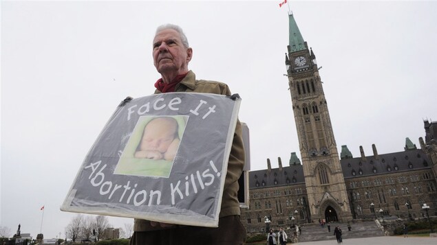 Un militant anti-avortement se tient devant le parlement à Ottawa.