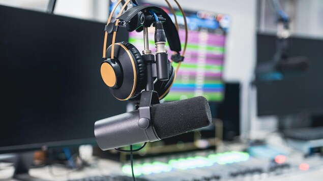 Des écouteurs sont posés sur un micro dans un studio de radio. 