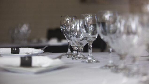Des verres et des assiettes sur une table avec une nappe blanche.