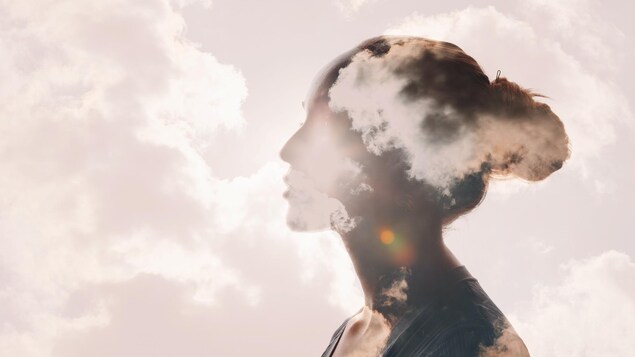 Portrait d'une femme qui a la tête dans les nuages grâce à un photomontage.