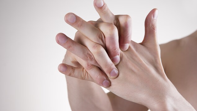 Se faire craquer les articulations, comme celles des doigts, ne poserait aucun danger pour la santé. Sur la photo : un homme se masse les doigts de la main gauche avec son autre main.